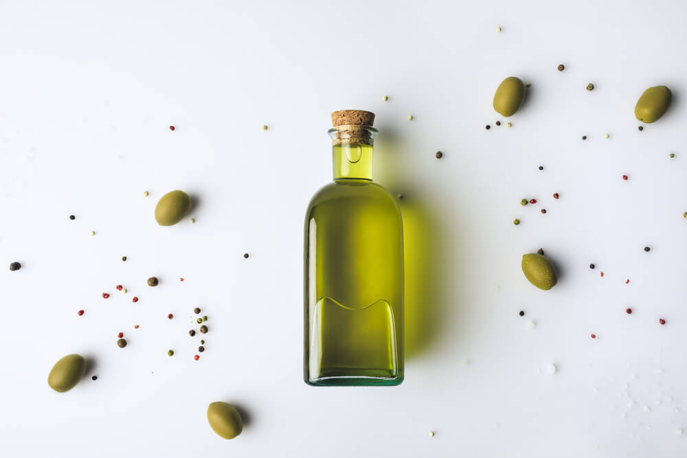 Top,View,Of,Glass,Bottle,With,Olive,Oil,And,Olives