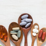 Variety,Of,Vitamin,Pills,In,Wooden,Spoon,On,White,Background